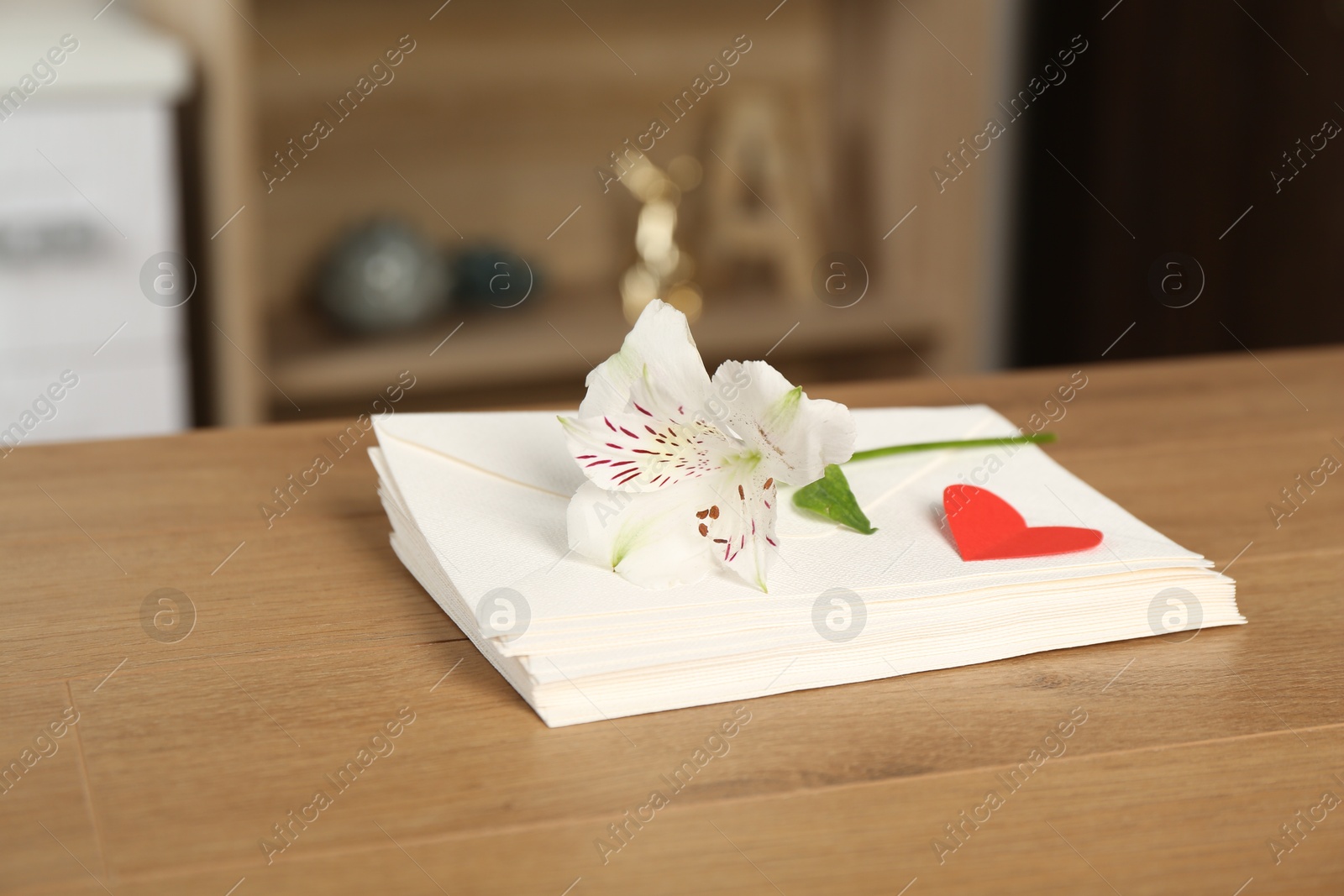 Stack of love letters, red heart and flower on wooden table indoors, closeup Photo of Stack of love letters, red heart and flower on wooden table indoors, closeup