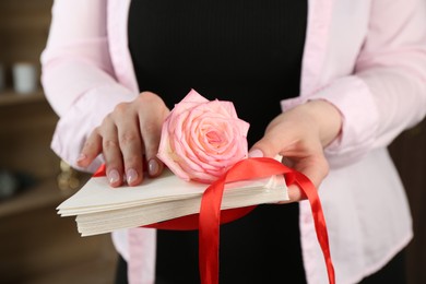 Photo of Woman with stack of love letters and rose flower indoors, closeup
