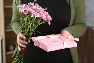 Photo of Woman with stack of love letters and flowers indoors, closeup