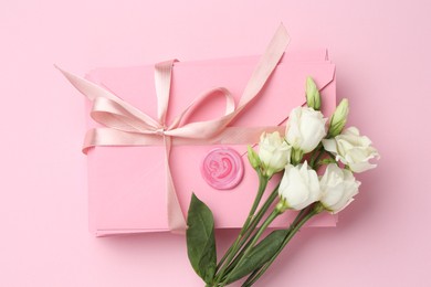 Photo of Stack of love letters and flowers on pink background, flat lay