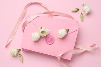 Photo of Stack of love letters, ribbon and flowers on pink background, flat lay