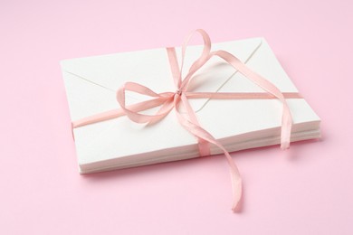 Photo of Stack of love letters on pink background, closeup
