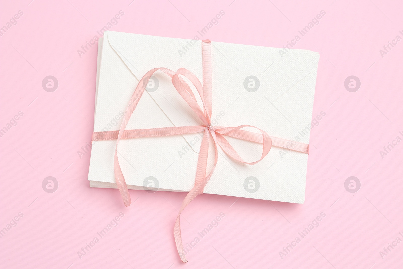 Stack of love letters on pink background, top view Photo of Stack of love letters on pink background, top view