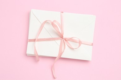 Photo of Stack of love letters on pink background, top view