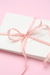 Photo of Stack of love letters on pink background, above view