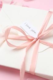 Photo of Stack of letters with phrase I Love You on pink background, above view