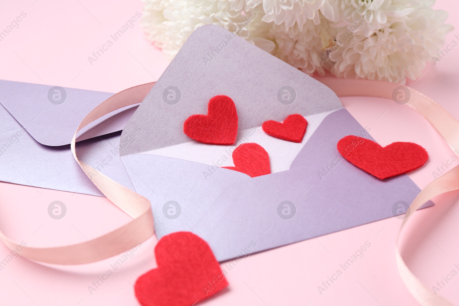 Love letters, red hearts, ribbon and flowers on pink background, closeup Photo of Love letters, red hearts, ribbon and flowers on pink background, closeup