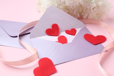 Photo of Love letters, red hearts, ribbon and flowers on pink background, closeup