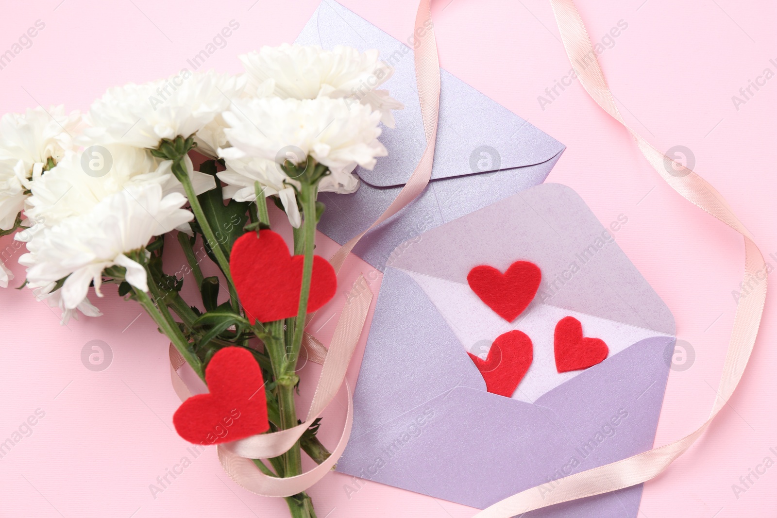 Love letters, red hearts, ribbon and flowers on pink background, flat lay Photo of Love letters, red hearts, ribbon and flowers on pink background, flat lay