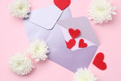Photo of Love letters, flowers and red hearts on pink background, flat lay