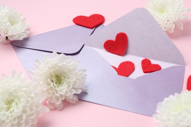 Photo of Love letters, flowers and red hearts on pink background, closeup