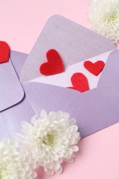 Photo of Love letters, flowers and red hearts on pink background, above view