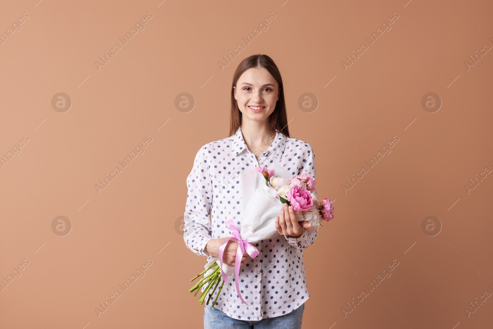 Woman with beautiful bouquet of peonies on dark beige background Photo of Woman with beautiful bouquet of peonies on dark beige background