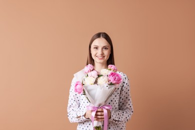 Photo of Woman with beautiful bouquet of peonies on dark beige background