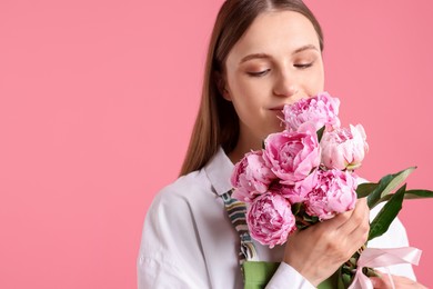 Photo of Florist with beautiful bouquet of peonies on pink background, space for text