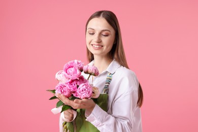 Photo of Florist with beautiful peonies on pink background