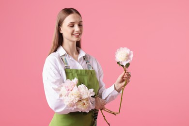 Photo of Florist with beautiful peonies on pink background