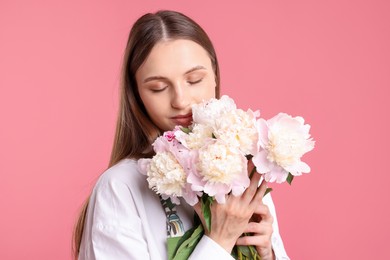 Photo of Florist with beautiful peonies on pink background