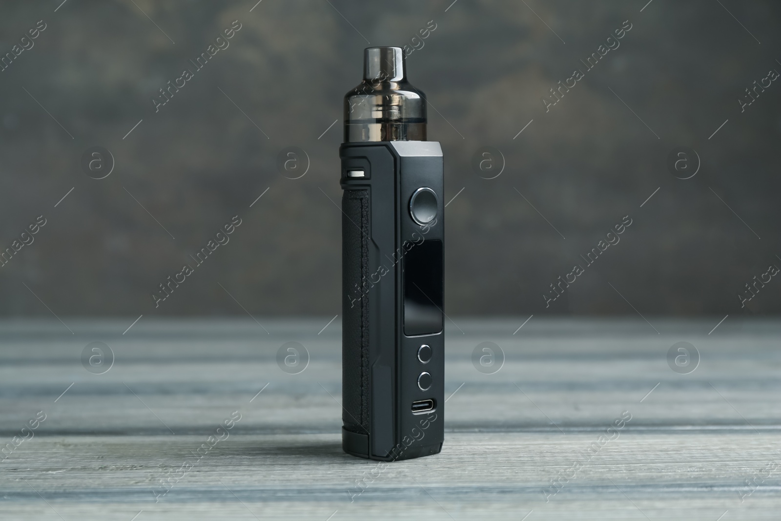 One electronic smoking device on wooden table against grey background, closeup Photo of One electronic smoking device on wooden table against grey background, closeup