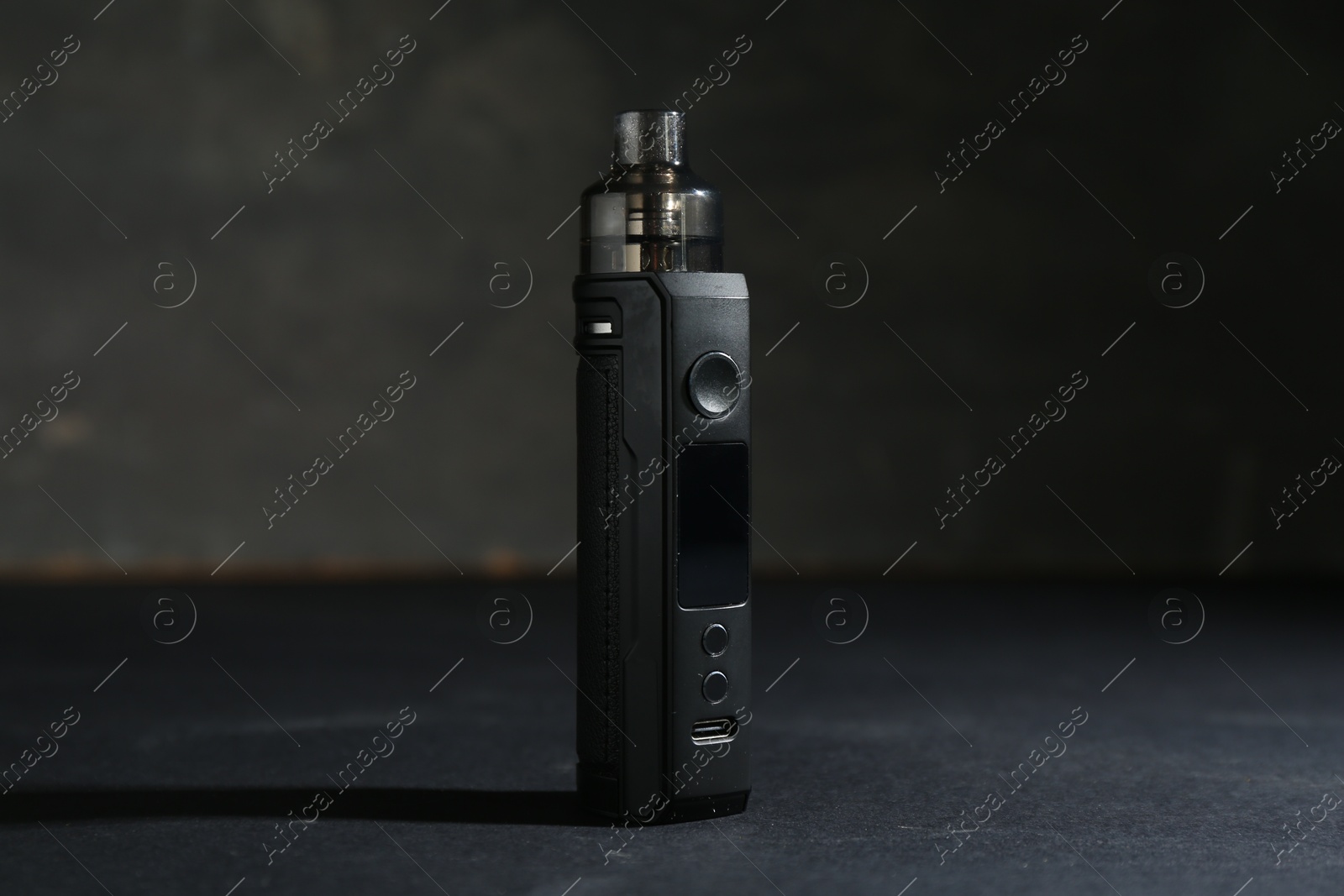 One electronic smoking device on dark table against grey background, closeup Photo of One electronic smoking device on dark table against grey background, closeup
