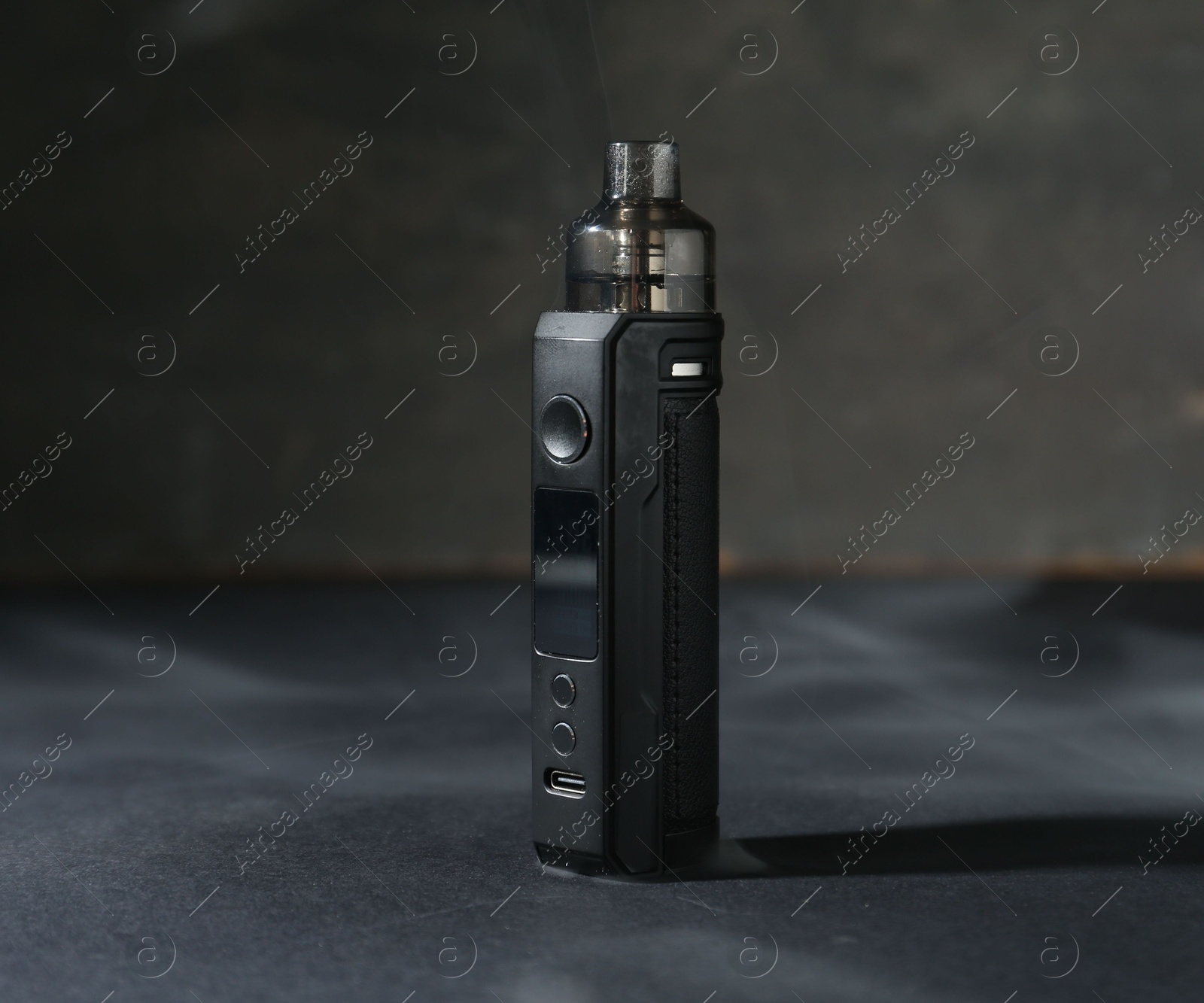 One electronic smoking device on dark table against grey background, closeup Photo of One electronic smoking device on dark table against grey background, closeup