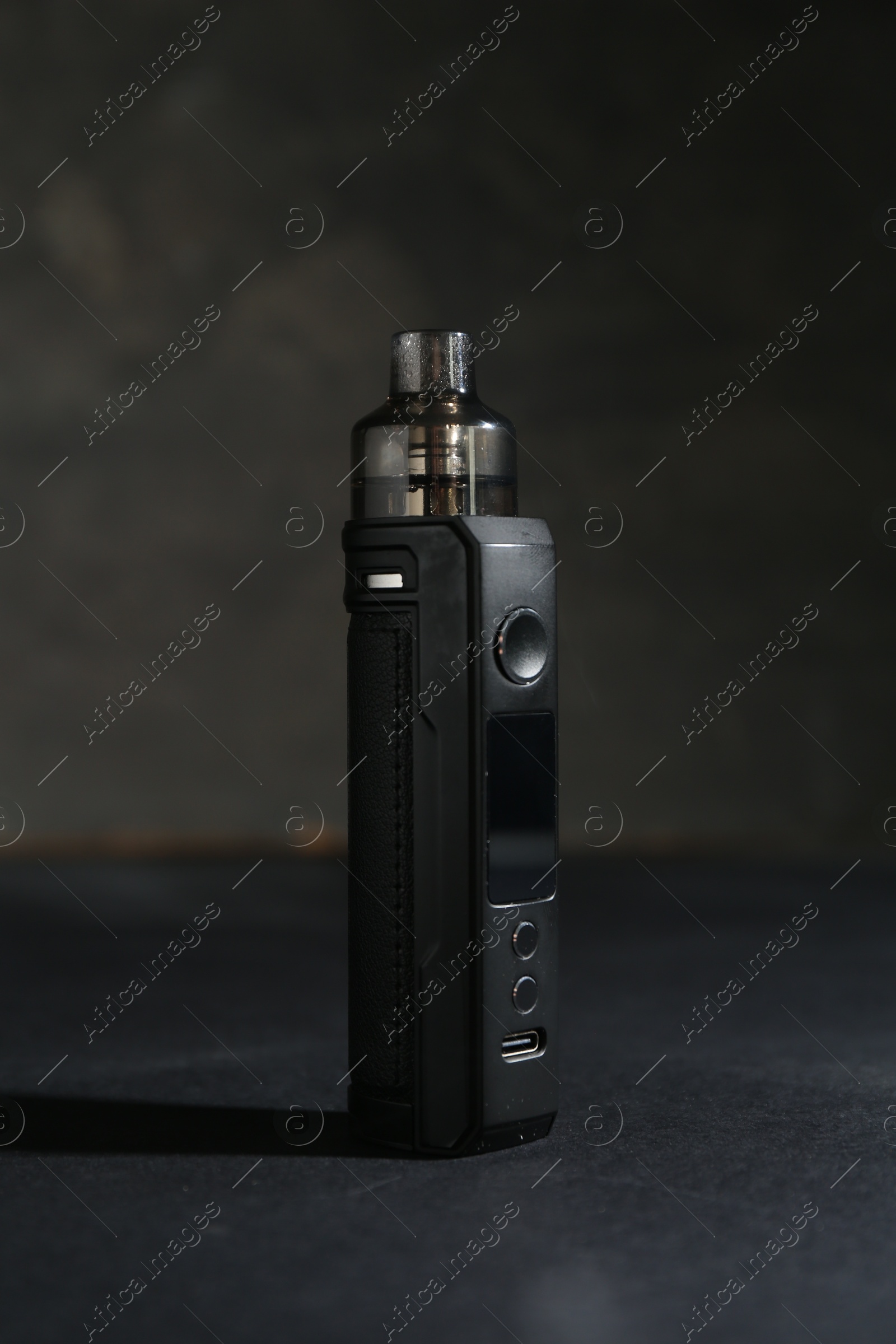 One electronic smoking device on dark table against grey background, closeup Photo of One electronic smoking device on dark table against grey background, closeup
