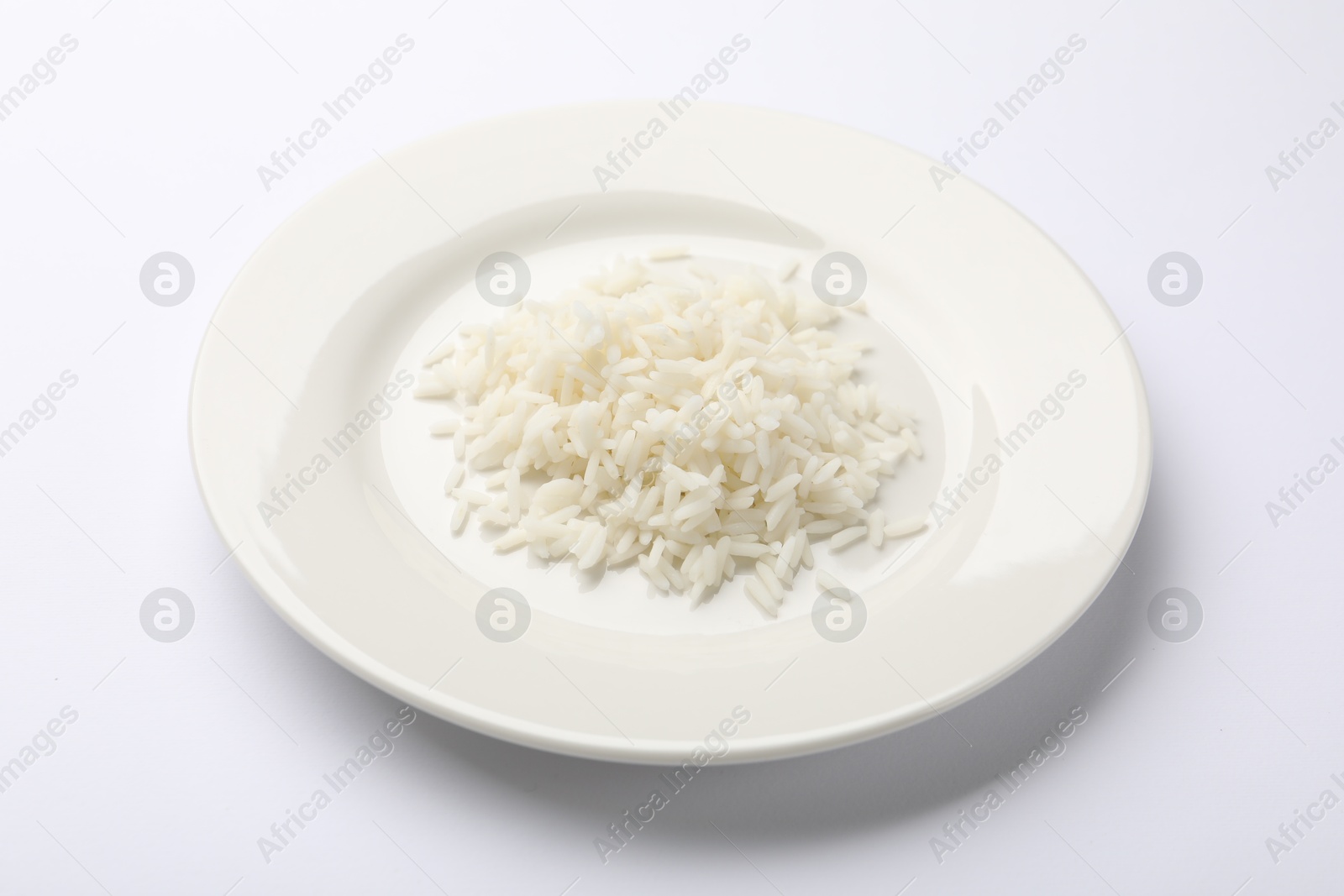 Pile of rice and plate on white table, closeup Photo of Pile of rice and plate on white table, closeup