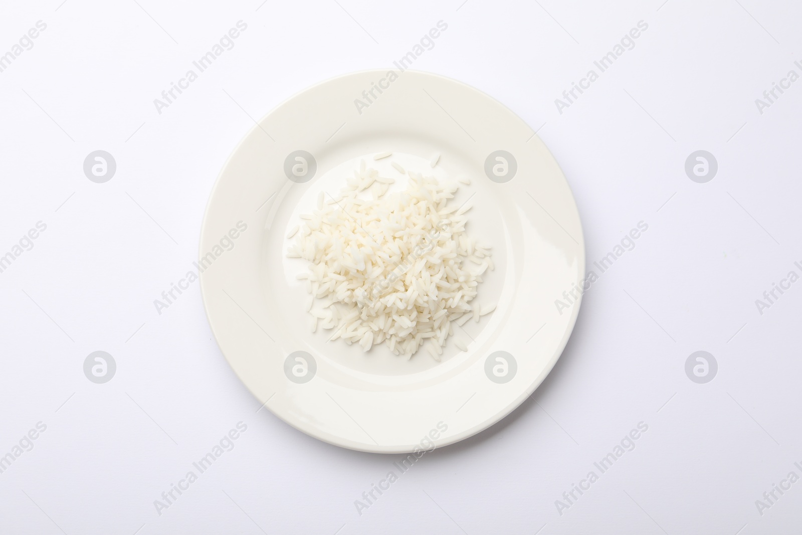Pile of rice and plate on white table, top view Photo of Pile of rice and plate on white table, top view