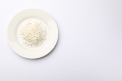 Photo of Pile of rice and plate on white table, top view. Space for text
