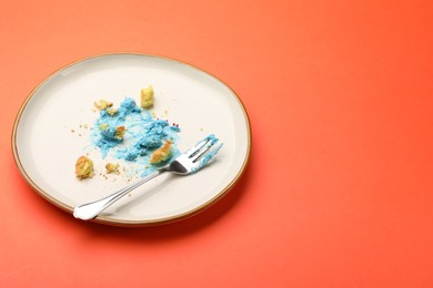 Photo of Dirty plate with crumbs, cream and fork on red table, closeup. Space for text
