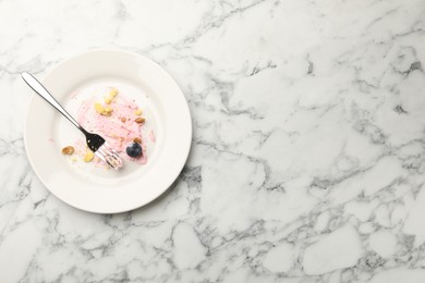 Photo of Dirty plate with crumbs, jam, blueberry and fork on white marble table, top view. Space for text