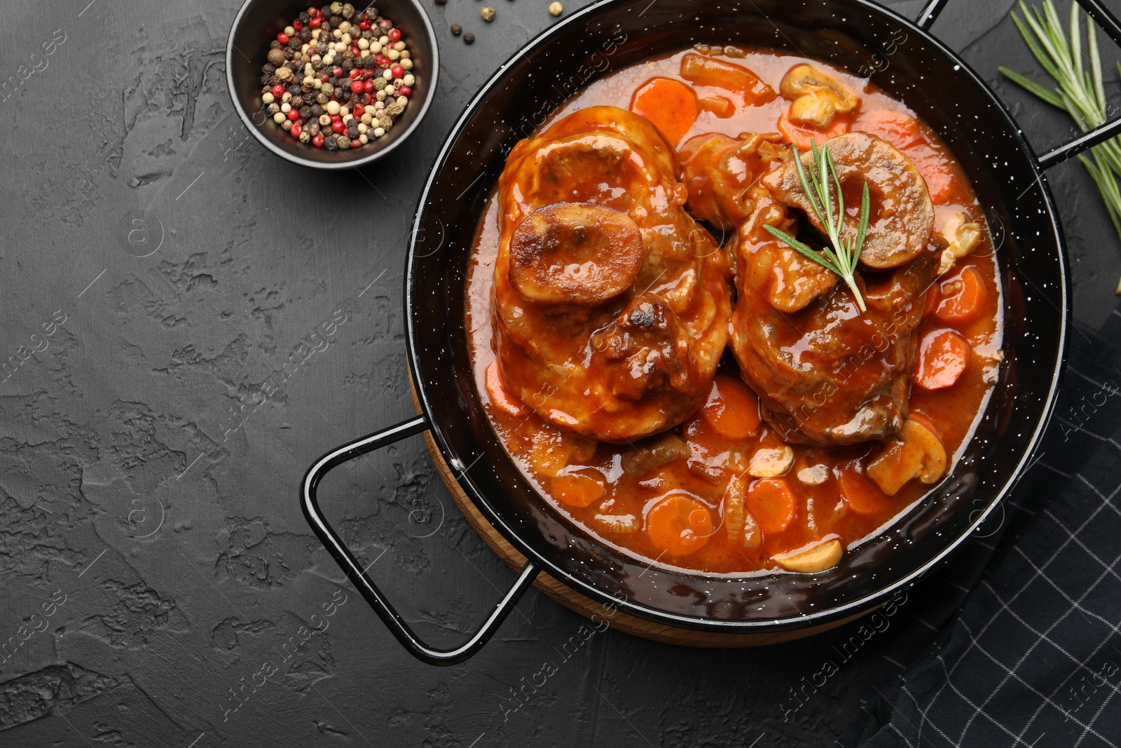 Tasty beef ossobuco with carrot and mushrooms on dark textured table, flat lay Photo of Tasty beef ossobuco with carrot and mushrooms on dark textured table, flat lay
