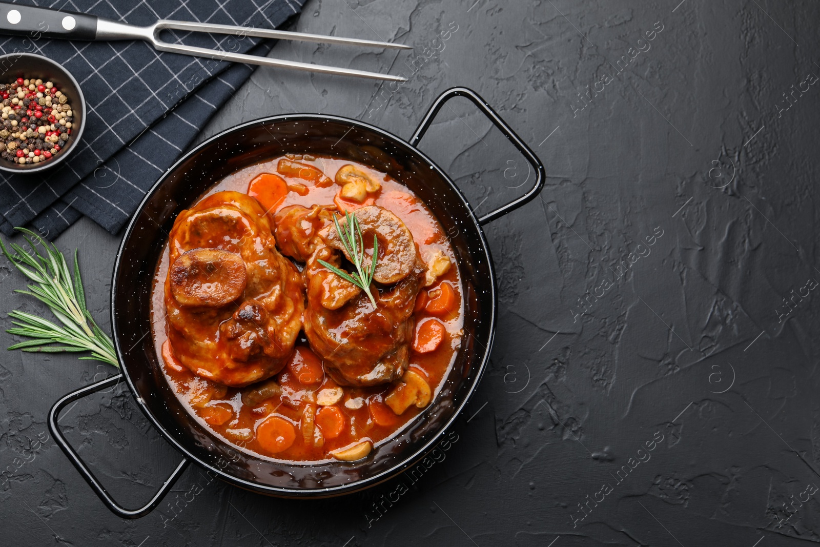 Tasty beef ossobuco with carrot and mushrooms served on dark textured table, flat lay. Space for text Photo of Tasty beef ossobuco with carrot and mushrooms served on dark textured table, flat lay. Space for text