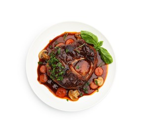 Photo of Tasty beef ossobuco with carrot, mushrooms and herbs isolated on white, top view
