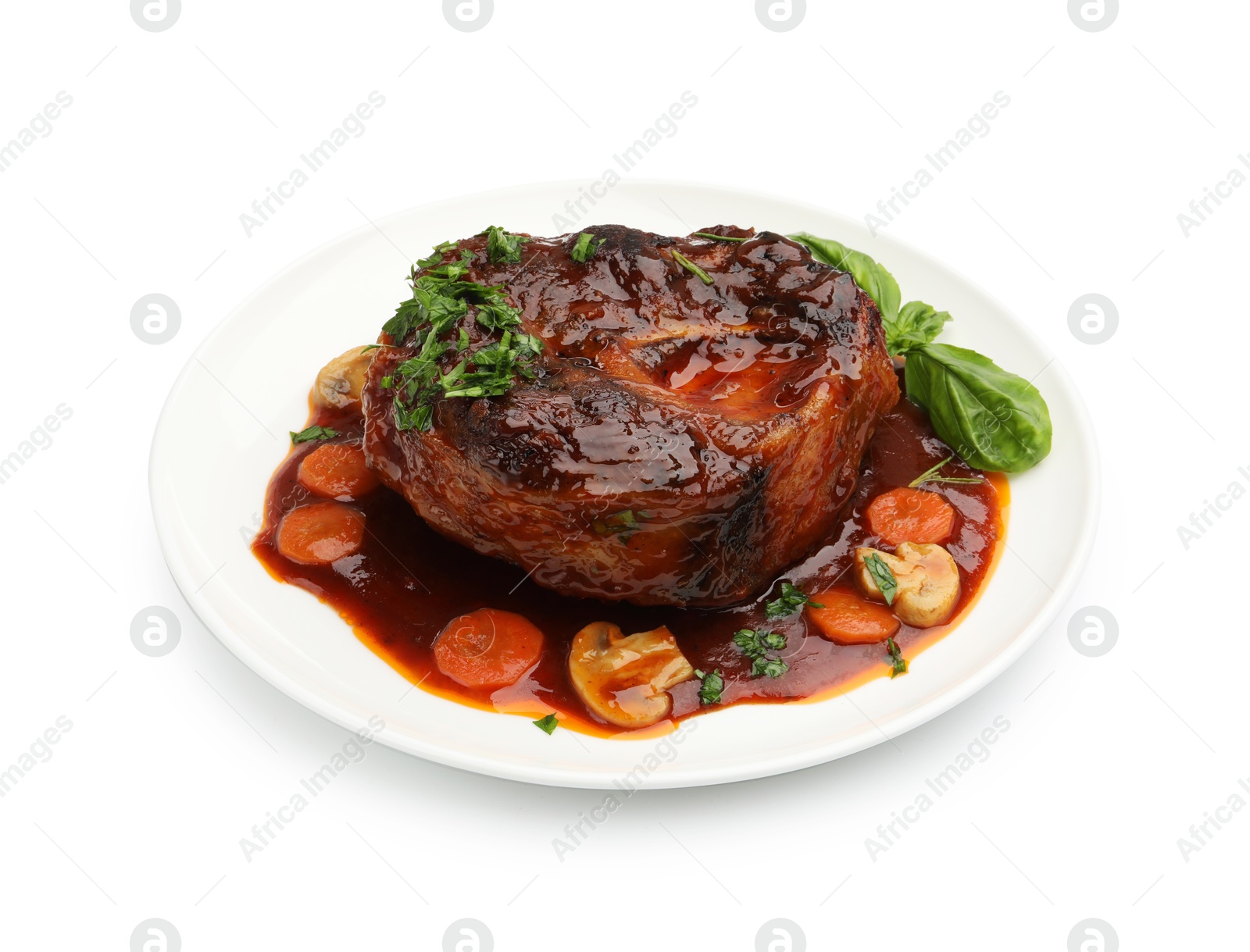 Photo of Tasty beef ossobuco with carrot, mushrooms and herbs isolated on white