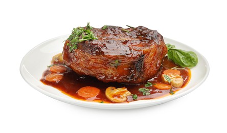 Photo of Tasty beef ossobuco with carrot, mushrooms and herbs isolated on white