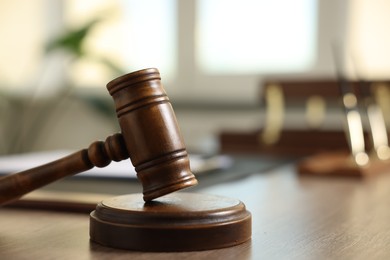 Photo of Judge's gavel on wooden table in office, closeup. Space for text