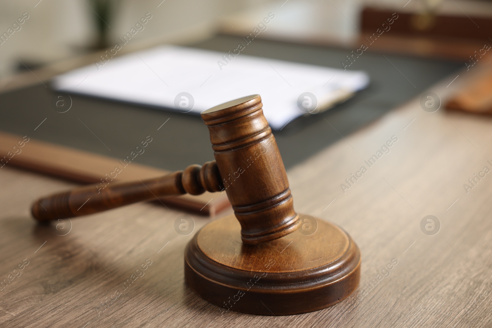 Photo of Judge's gavel on wooden table in office, closeup. Space for text