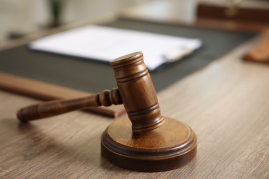 Photo of Judge's gavel on wooden table in office, closeup. Space for text