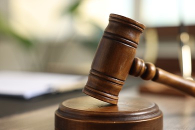 Photo of Judge's gavel on wooden table in office, closeup. Space for text