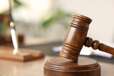 Photo of Judge's gavel on wooden table in office, closeup. Space for text