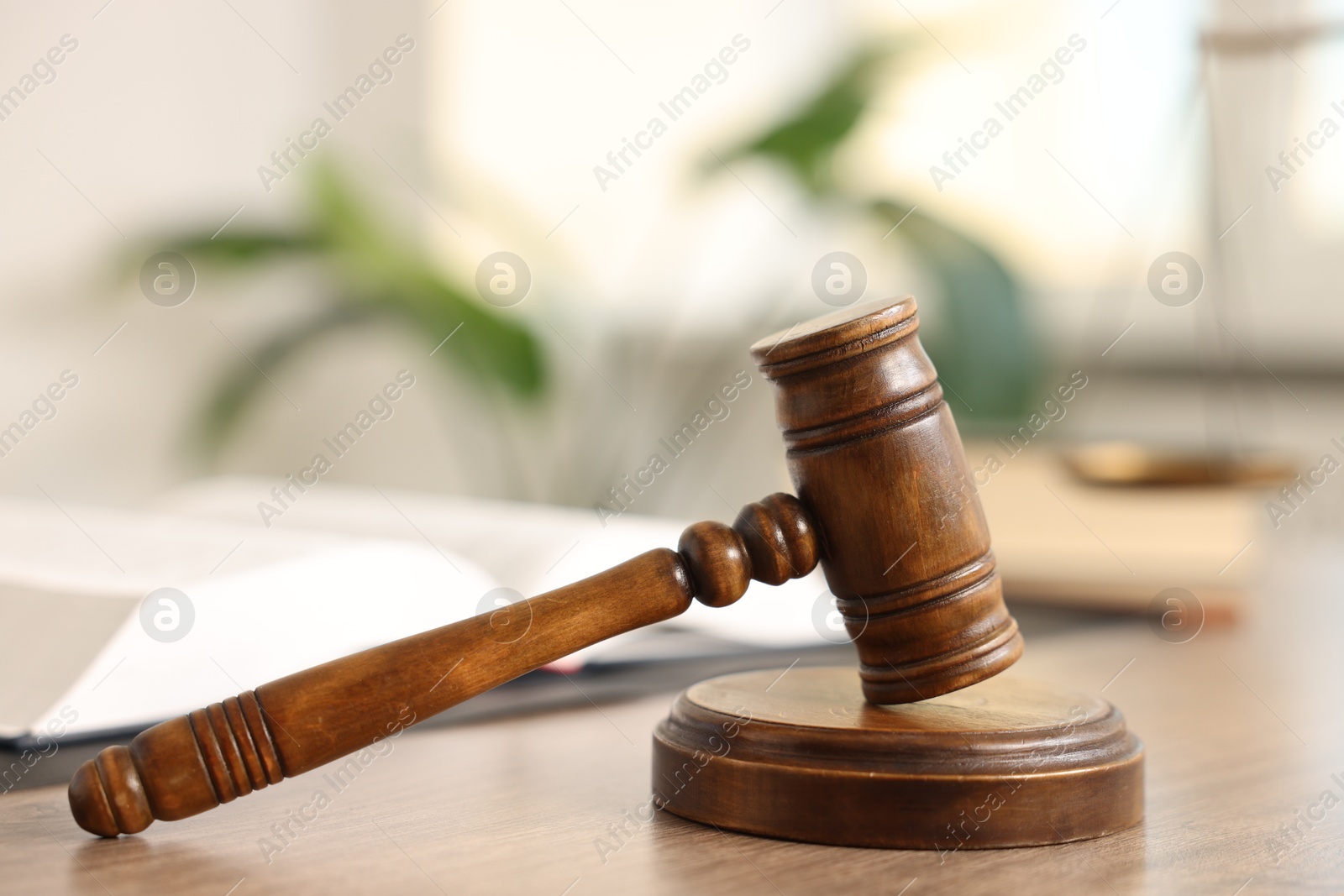 Photo of Judge's gavel on wooden table in office, closeup