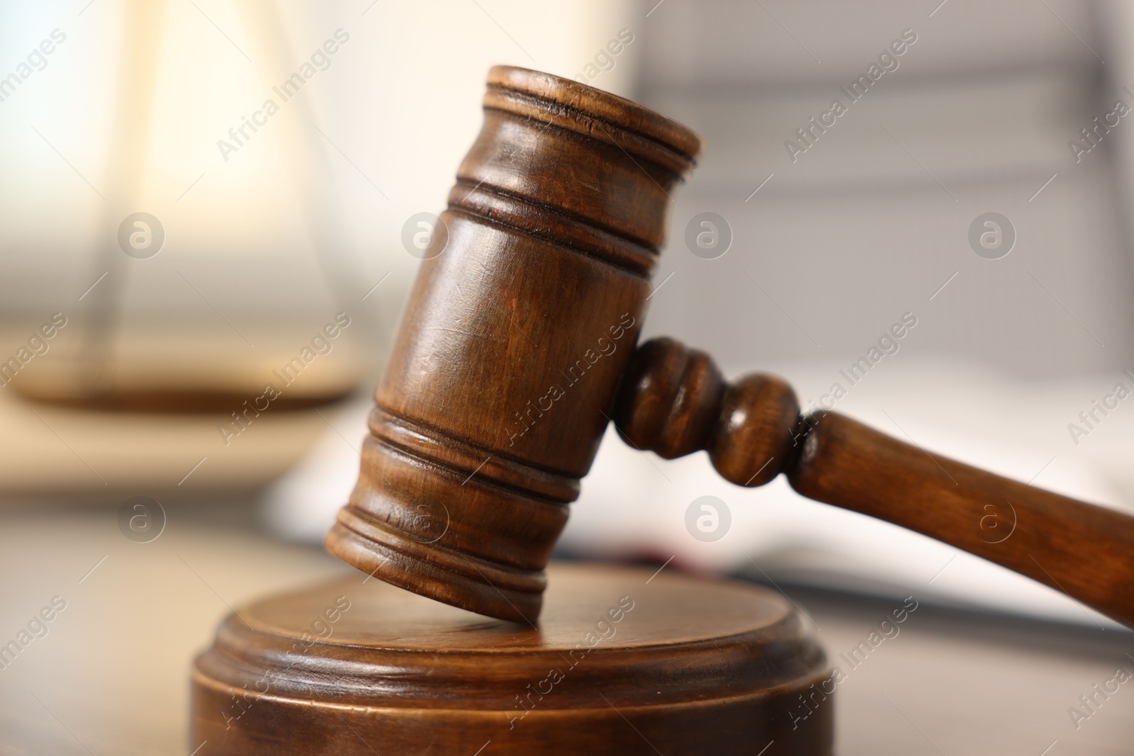 Photo of Judge's gavel on wooden table in office, closeup