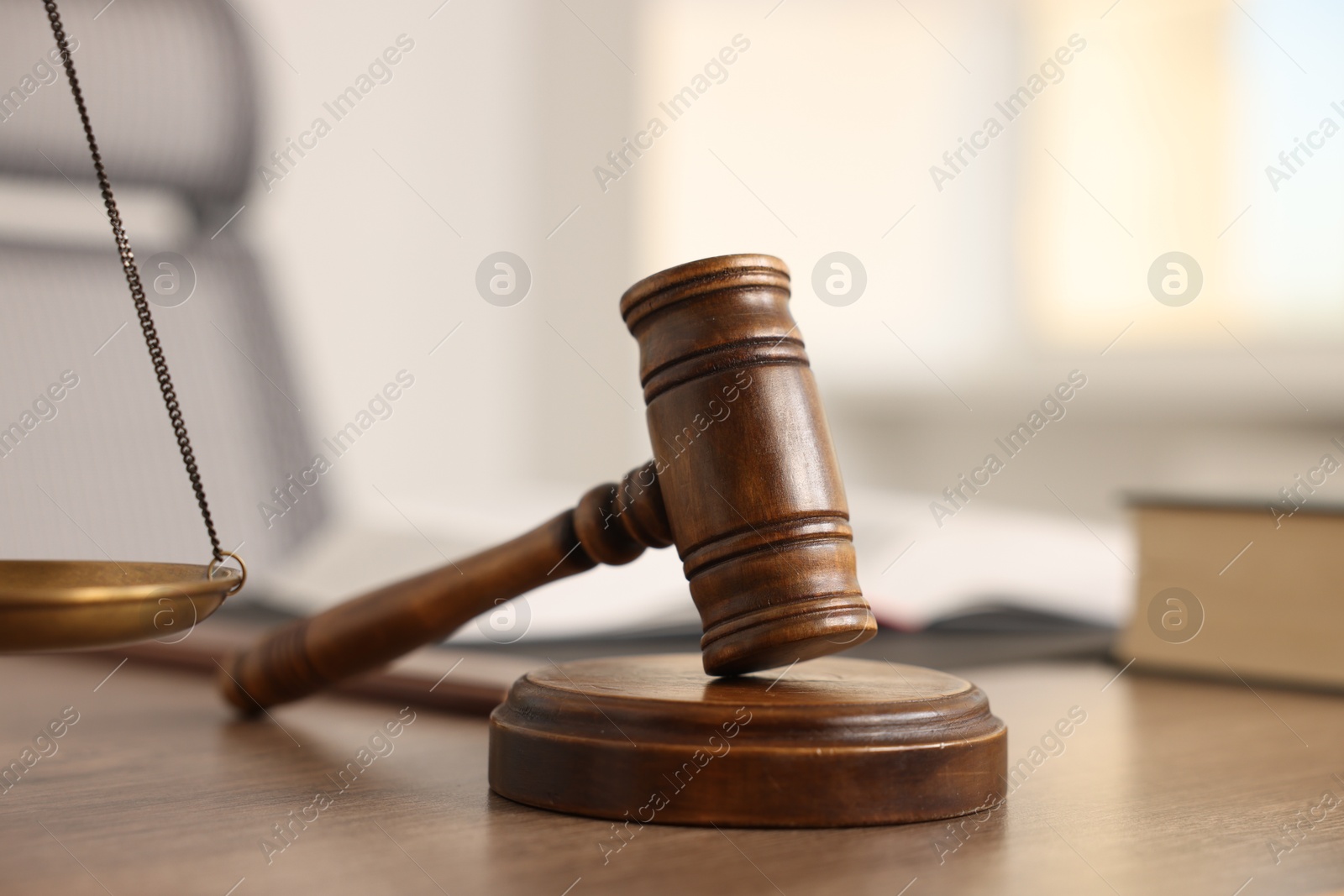 Photo of Judge's gavel on wooden table in office, closeup