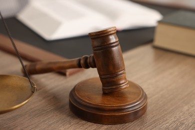 Photo of Judge's gavel on wooden table in office, closeup