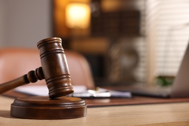 Photo of Judge's gavel on wooden table in office, closeup. Space for text