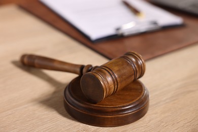 Photo of Judge's gavel on wooden table in office, closeup