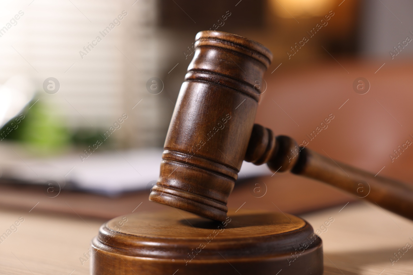 Photo of Judge's gavel on wooden table in office, closeup