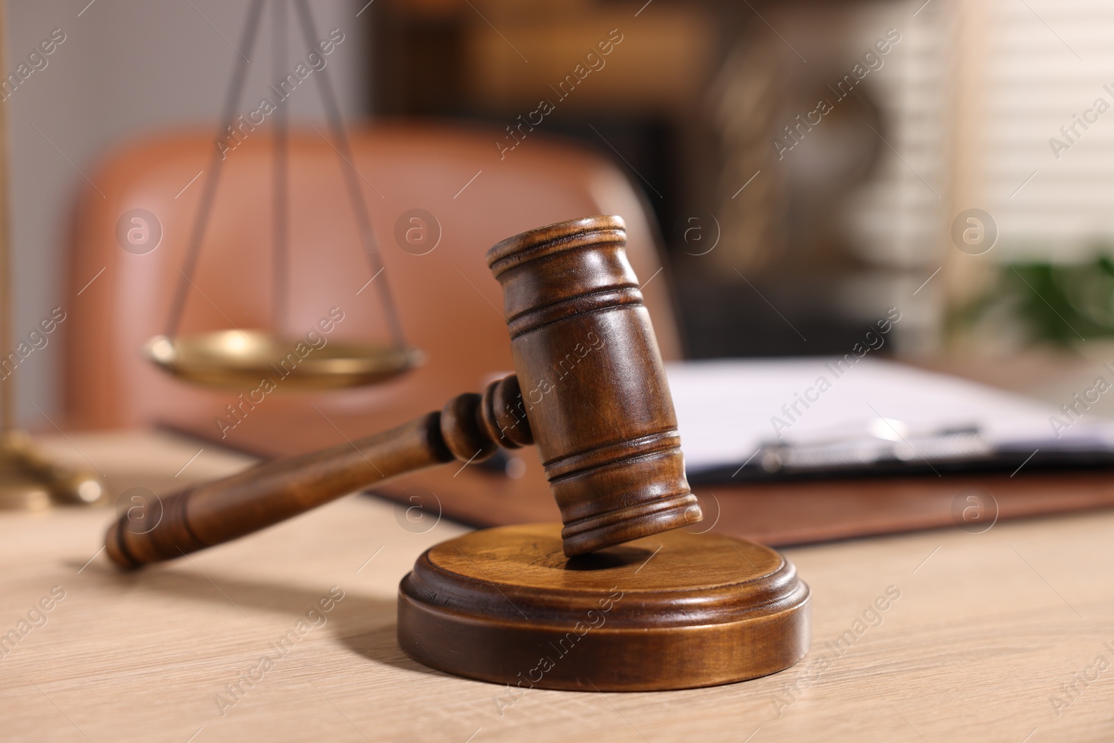 Photo of Judge's gavel on wooden table in office, closeup