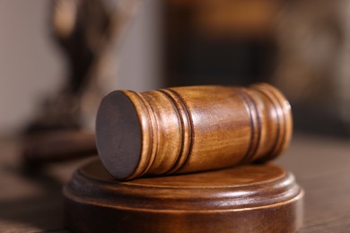 Photo of Judge's gavel on wooden table in office, closeup